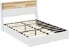 A white upholstered bed frame with a slatted base and a headboard with built-in shelves. Produktbild-Vorschau
