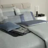 A neatly made bed with striped bedding and pillows. Produktbild-Vorschau