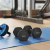 A set of black dumbbells and an ab roller on a blue exercise mat in a gym. Produktbild-Vorschau