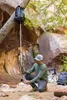 A man is using a gravity water purifier in a natural canyon setting. Produktbild-Vorschau