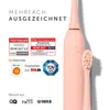 A pink electric toothbrush with its brush head detached, surrounded by awards and certifications. Náhled obrázku produktu