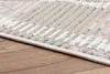A close-up view of a rug with a geometric pattern, placed on a wooden floor. Produktbild-Vorschau