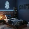 A bedroom decorated with Harry Potter themed items, featuring a bed with bedding, a nightstand with a lamp, a bookshelf, and wall art. Produktbild-Vorschau