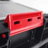 A close-up of a red plastic accessory attached to a black modular storage system. Produktbild-Vorschau