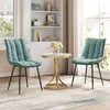 Two turquoise chairs and a small round table with a vase of flowers in a well-lit room. Produktbild-Vorschau