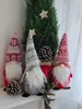 Three Christmas gnomes are displayed on a shelf with a small evergreen tree and pinecones. Náhľad obrázku produktu