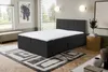 A bedroom scene with a bed, rug, and artwork. Voir les images du produit