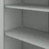 A close-up view of the interior of a gray metal cabinet, showing multiple shelves and the perforated side panels for shelf adjustment. Náhľad obrázku produktu