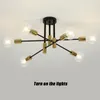 A modern, multi-arm ceiling light fixture with exposed bulbs, mounted on a white ceiling. Produktbild-Vorschau