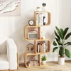 A modern living room with a white couch, a wooden S-shaped bookshelf filled with books and decor, and a large potted plant. Podgląd zdjęcia produktu