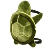 A plush turtle-shaped backpack shown from a side-diagonal angle against a white background. Podgląd zdjęcia produktu