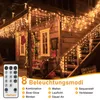 A wooden house decorated with icicle lights for Christmas. Produktbild-Vorschau