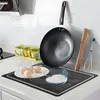 A kitchen counter with baking supplies including a silicone baking mat, eggs, flour, a wok, a rolling pin, and a whisk. Voir les images du produit