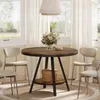 A round dining table with chairs in a well-lit room with large windows. Produktbild-Vorschau
