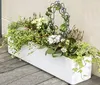 A white planter box filled with various plants and flowers, placed on a wooden surface. Náhled obrázku produktu