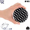 A hand holding a black lid with white polka dots, with measurement indicators and weight information. Podgląd zdjęcia produktu
