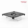 A black mesh grill with silver legs sits on a white surface with a reflection. Produktbild-Vorschau