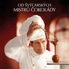 A chef in a white uniform and hat is creating a chocolate sculpture. Anteprima dell’immagine prodotto