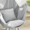 Close-up of a gray fabric hanging chair with two pillows and a side pocket containing a piece of paper. Produktbild-Vorschau