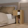 A bedside table next to a bed with pillows and a duvet. Anteprima dell’immagine prodotto