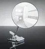 A close-up of a chrome clip-on magnifying mirror reflecting a modern bathroom. Produktbild-Vorschau