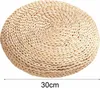 A round woven cushion on a white background. Produktbild-Vorschau