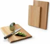 Two wooden cutting boards, one with a zucchini and sliced zucchini on it, and a knife. Voir les images du produit