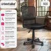 A black mesh office chair is shown from the front in a room with wooden floors and brick walls. Náhled obrázku produktu