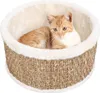 An orange kitten sits in a round cat bed made of woven seagrass with a fluffy white lining. Náhled obrázku produktu