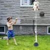 A young boy is playing with a water gun and a rocket-shaped sprinkler in a backyard. Produktbild-Vorschau
