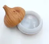A humidifier with a wood-grain lid is shown with the lid slightly ajar, revealing the white interior of the humidifier base. Podgląd zdjęcia produktu