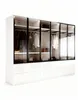 A modern, white high-gloss wardrobe with glass doors and black frames, showcasing hanging clothes and shelves. Produktbild-Vorschau