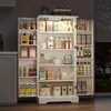 A tall, white, multi-shelf kitchen cabinet filled with various food items and kitchenware. The cabinet is illuminated by LED lights on some shelves. Anteprima dell’immagine prodotto