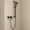 A black shower faucet and showerhead mounted on a tiled wall. Anteprima dell’immagine prodotto
