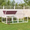 A white wooden chicken coop with a red roof sits on a green lawn in front of a white fence and trees. Náhled obrázku produktu