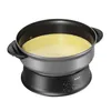 A black and silver electric wok and fondue pot filled with a yellow liquid, set against a white background. Produktbild-Vorschau