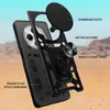 A disassembled phone case with labels pointing out its features, set against a desert-like background. Produktbild-Vorschau