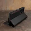A black leather phone case with red stitching is displayed on a textured surface. Anteprima dell’immagine prodotto