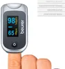 A finger wearing a pulse oximeter is shown against a white background. Text and branding are visible on the device and to the right of it. Podgląd zdjęcia produktu