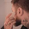 A man is using a gua sha stone on his face. Podgląd zdjęcia produktu