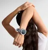 A person stretching their arms behind their head, wearing a smartwatch. Podgląd zdjęcia produktu