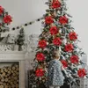 A child stands in front of a decorated Christmas tree, with a fireplace and logs in the foreground. Produktbild-Vorschau