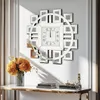 A decorative wall clock with a circular frame and square photo frames arranged around it, mounted on a white wall above a console table with books and decorative items. Anteprima dell’immagine prodotto