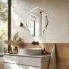 A modern bathroom vanity with a vessel sink and a decorative mirror above it. Natural light streams in from a large window. Anteprima dell’immagine prodotto