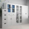 A collection of white metal storage cabinets and a filing cabinet in an office or storage room setting. Voir les images du produit