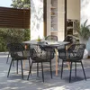 An outdoor dining set with black chairs and a black table on a patio. Voir les images du produit