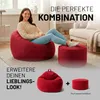 A woman sitting on a large red beanbag chair in a living room, with a smaller red ottoman next to her. The image also shows smaller versions of the beanbag and ottoman at the bottom, with a plus sign between them. Voir les images du produit