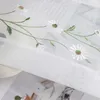 Close-up of embroidered daisies on a sheer white fabric, likely a curtain or blind. Produktbild-Vorschau