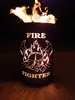 A fire pit with a firefighter motif burning at night. Produktbild-Vorschau