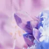 A close-up, abstract view of purple and blue crystals with a soft, blurred purple background. Anteprima dell’immagine prodotto